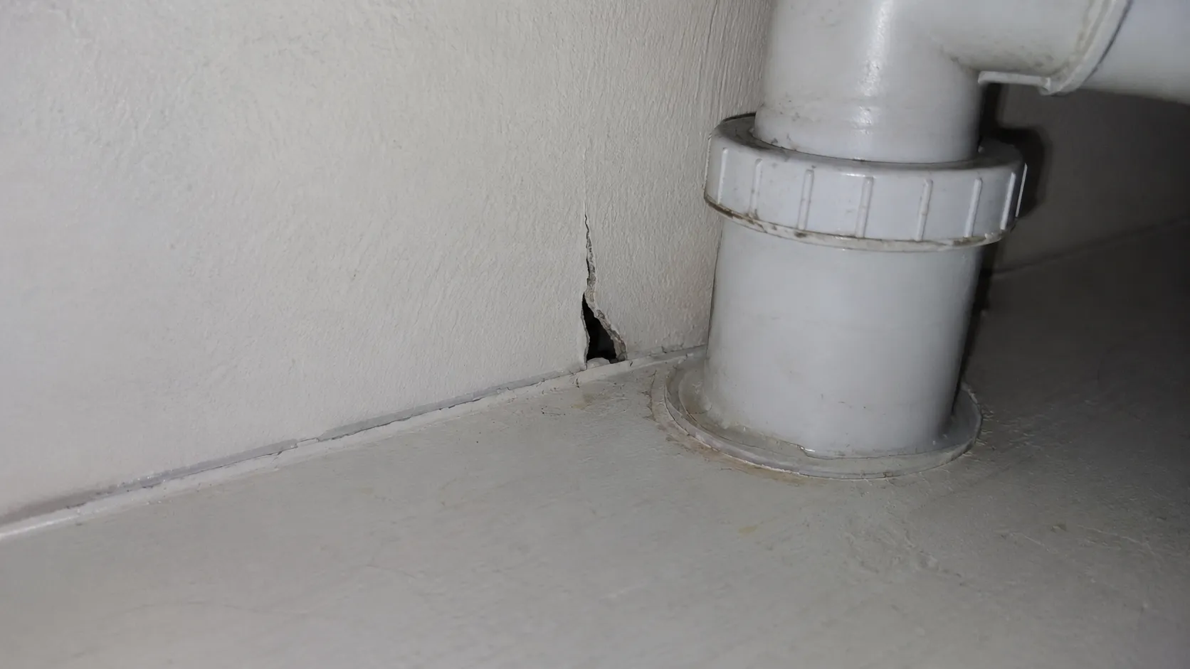 Fissure près d’une canalisation de cuisine pouvant servir de point d’entrée aux cafards