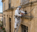 Technicien Fieri Nuisible posant des filets anti-oiseaux sur une façade en Occitanie